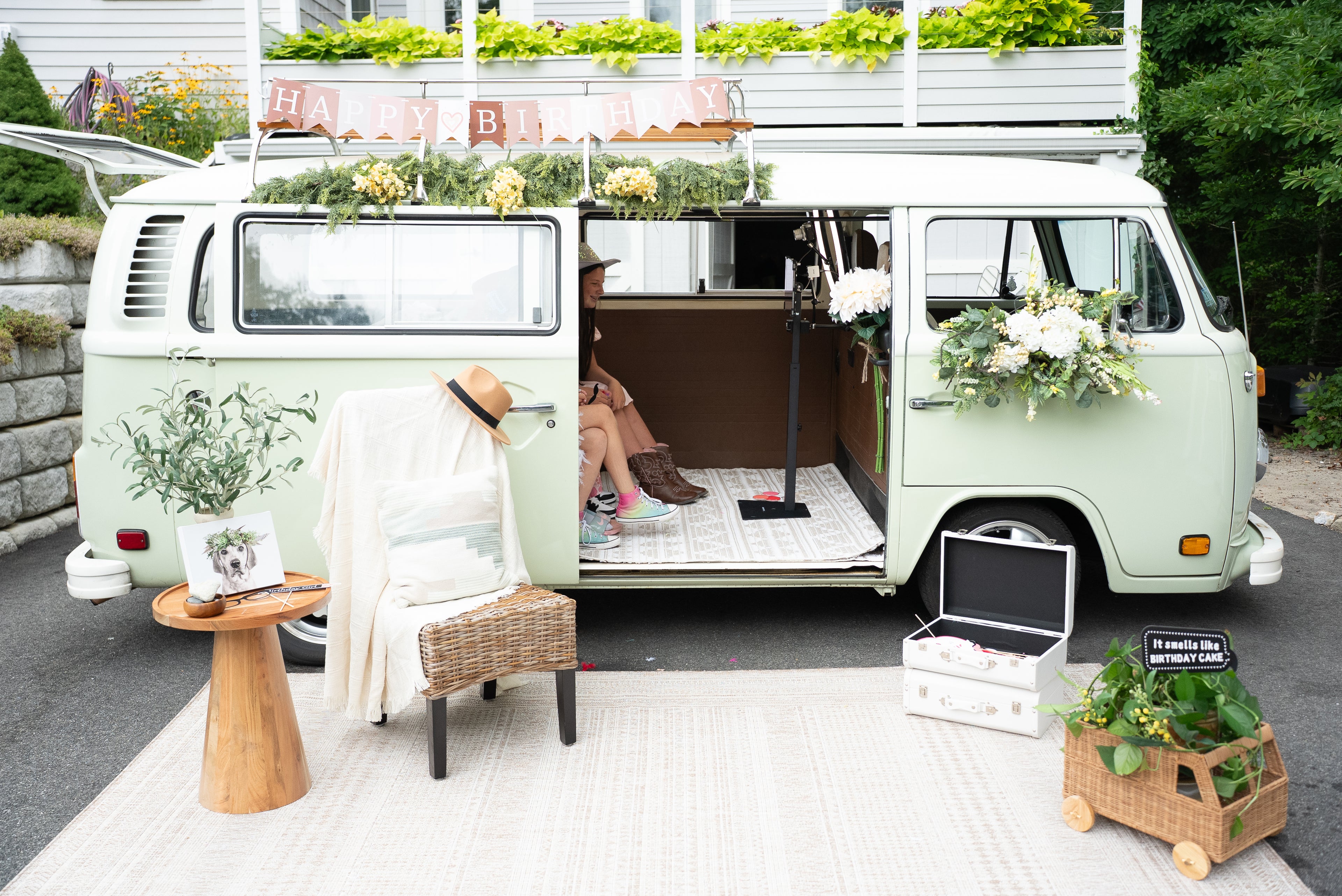 Vintage van converted into a mobile outdoor living space with furniture and decor.