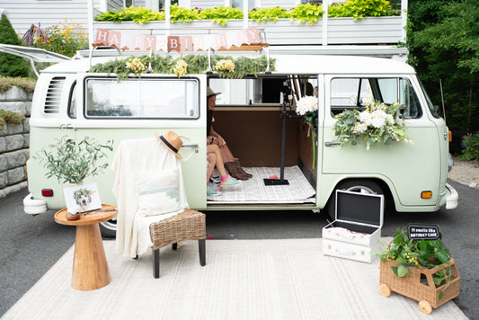 Vintage van converted into a mobile outdoor living space with furniture and decor.